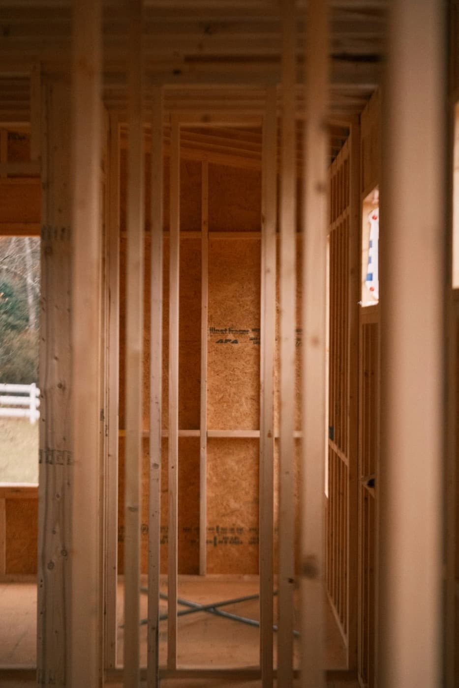 Interior of an RTWY rehab mid-build — new stud framing in warm daylight