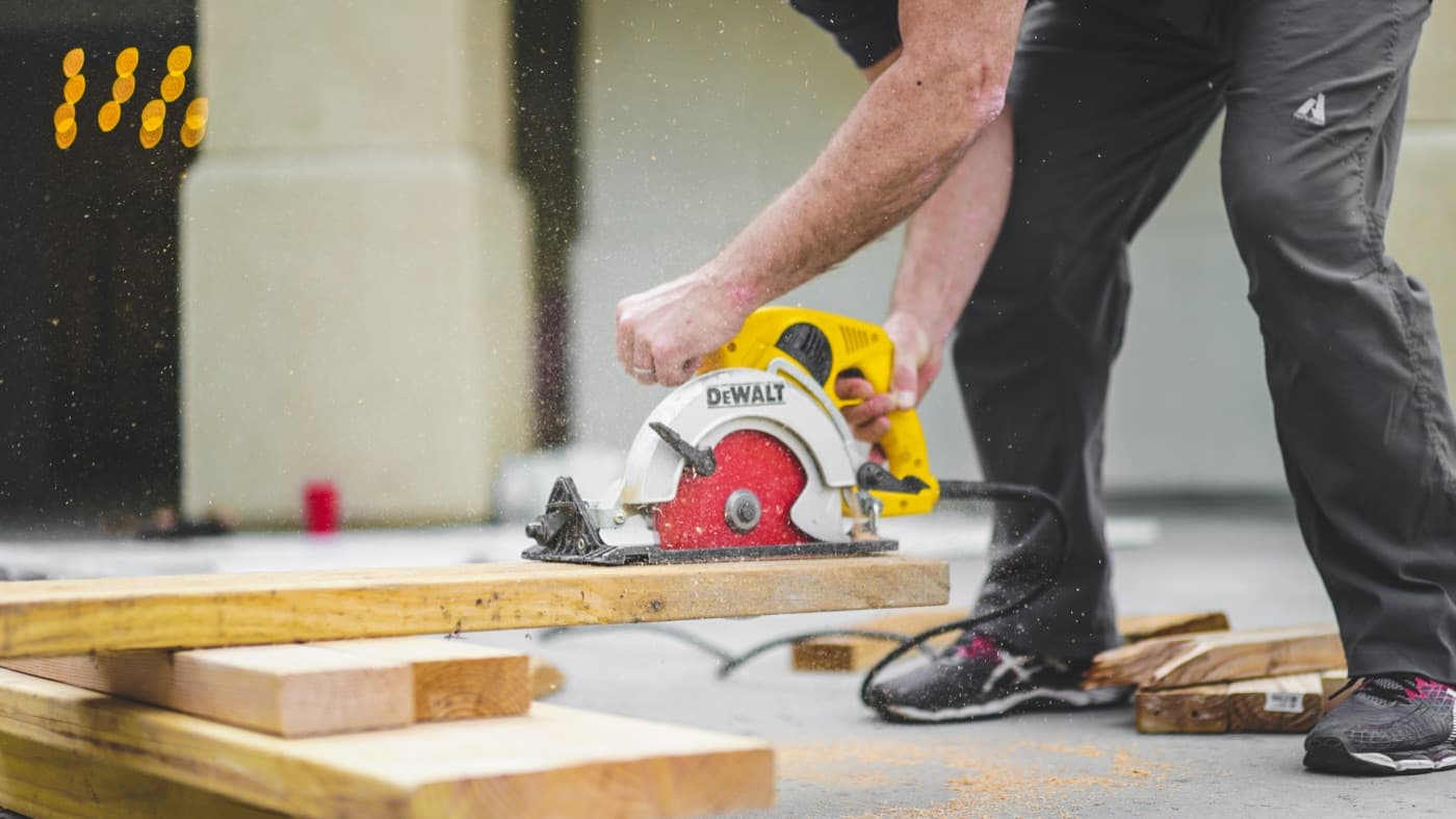A carpenter cutting framing lumber with a circular saw on site